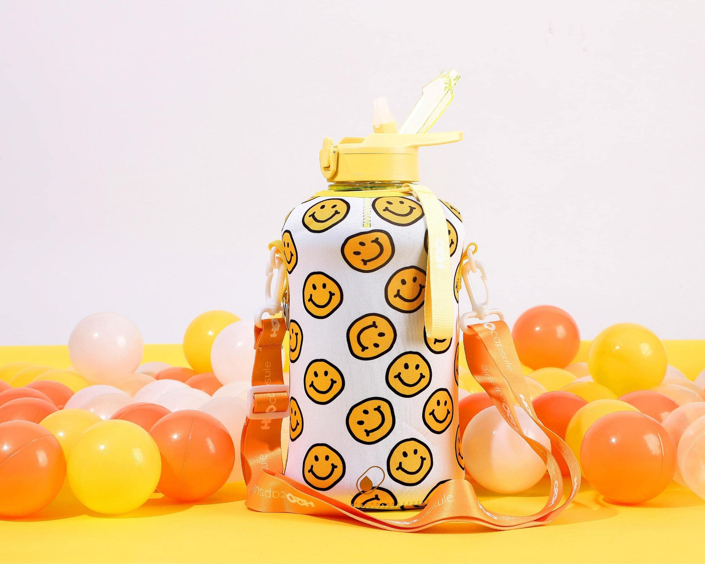 H2O Capsule 2.2L Half Gallon Water Bottle with Storage Sleeve and Covered Straw Lid – BPA Free Large Reusable Drink Container with Handle - Big Sports Jug, 2.2 Liter (74 Ounce) Happy Day